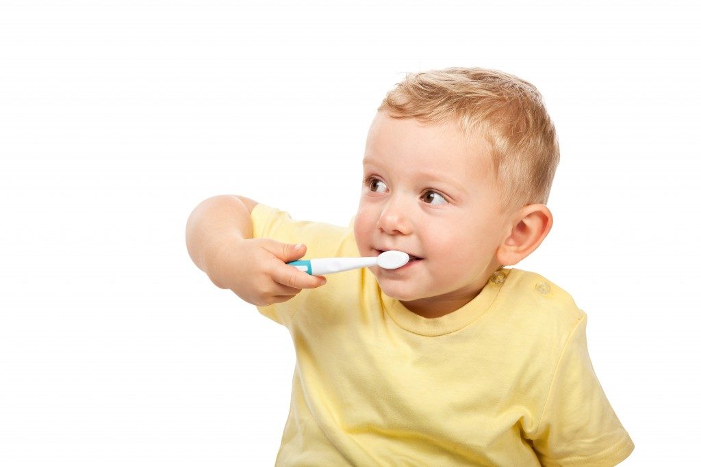 little boy brushing his teeth