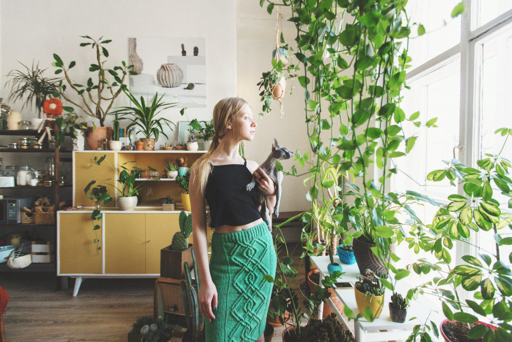 woman with cat and her house filled with houseplants