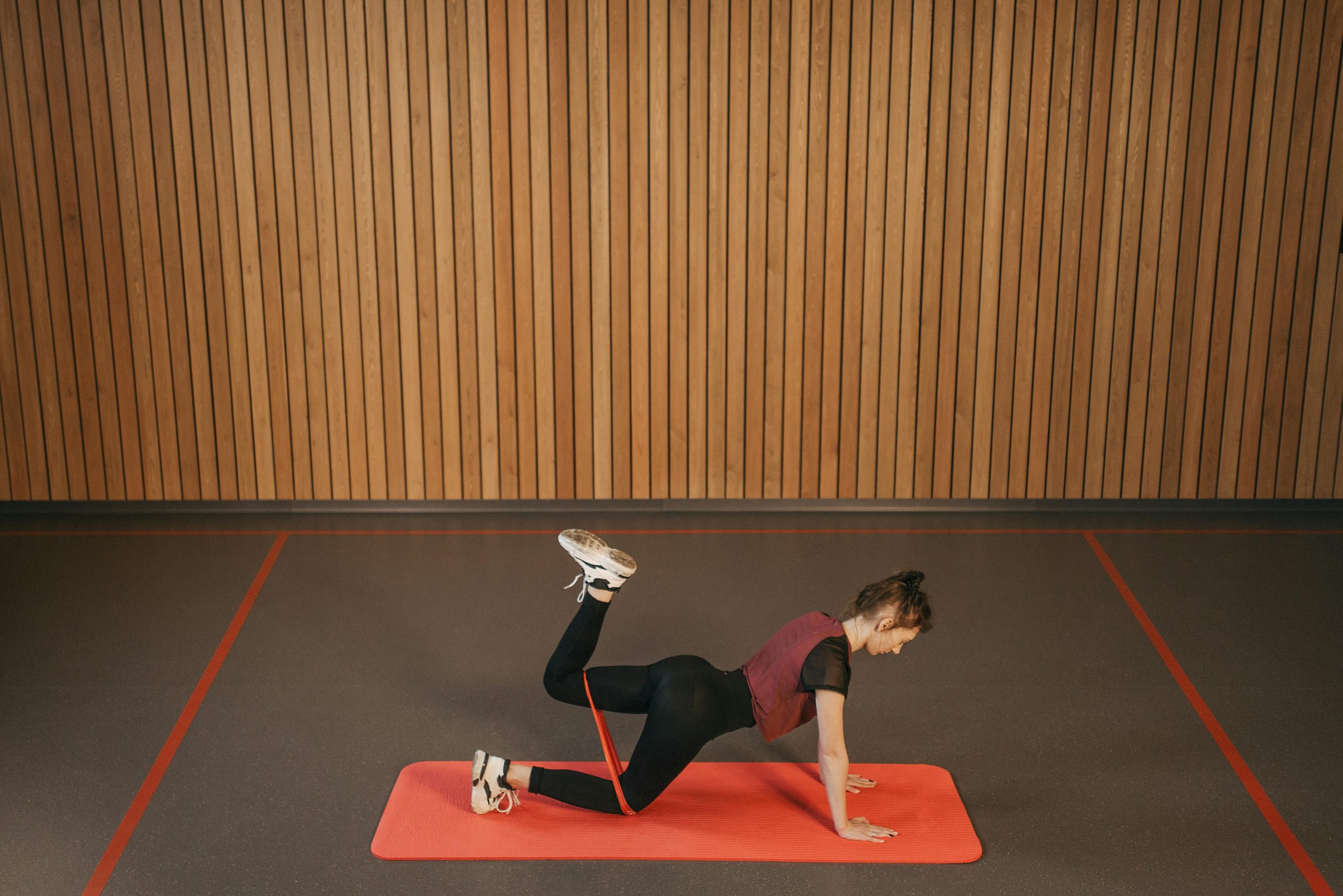 woman using a resistance band to stretch on a yoga mat